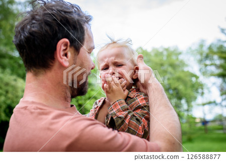 Loving father helping to injured crying toddler boy. 126588877