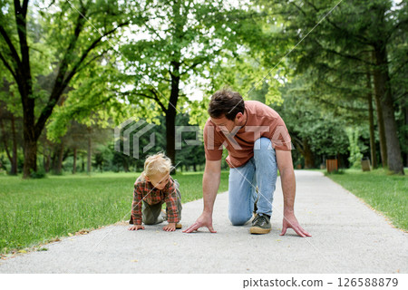 Father lining up to have a running race with his little son. 126588879