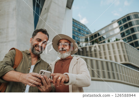 Father showing odler son something in smartphone, sharing a joyful moment . 126588944