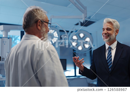 Hospital director talking with doctori in examination room. 126588987