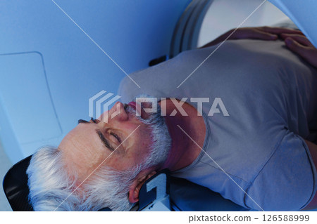 Male patient undergoing CT scan examination in hospital. 126588999