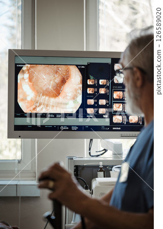 Doctor looking at monitior during gastroscopy procedure, examining upper digestive tract. Doctor looking at monitior during gastroscopy procedure, examining upper digestive tract. 126589020