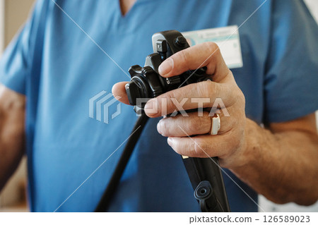 Close-up of doctor holding endoscope control in gastroenterology clinic. Close-up of doctor holding endoscope control in gastroenterology clinic. 126589023