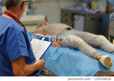 Medical professional examining health record patient lying on examination table 126589026