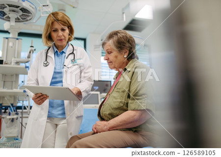 Geriatrician talking about test results with senior patient during check-up. Geriatrician talking about test results with senior patient during check-up. 126589105