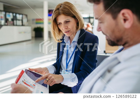 Pharmaceutical rep and doctor discussing drug samples and prescriptions Pharmaceutical rep and doctor discussing drug samples and prescriptions 126589122