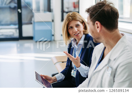 Pharmaceutical rep and doctor explaining new medication and prescriptions Pharmaceutical rep and doctor explaining new medication and prescriptions 126589134