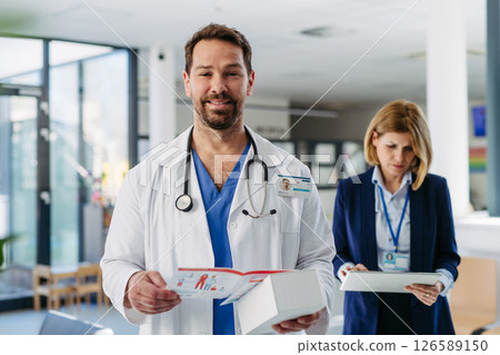 Handsome doctor and pharmaceutical rep meeting to discuss new drugs. Handsome doctor and pharmaceutical rep meeting to discuss new drugs. 126589150