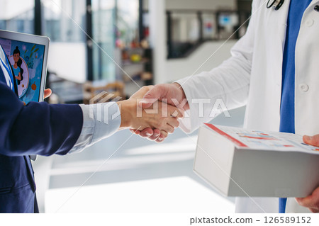 Pharmaceutical rep meeting with healthcare professional to discuss new drugs 126589152