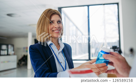 Female medical sales representative introducing pharmaceutical products to doctor. 126589158