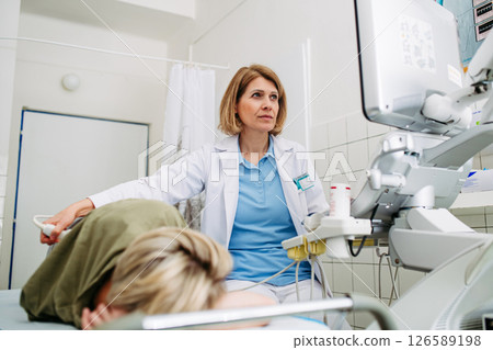 Medical examination with ultrasound probe on lower back 126589198