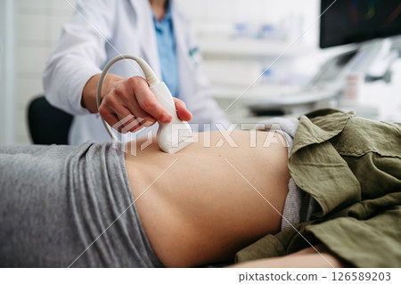 Female patient undergoing abdominal ultrasound screening. 126589203