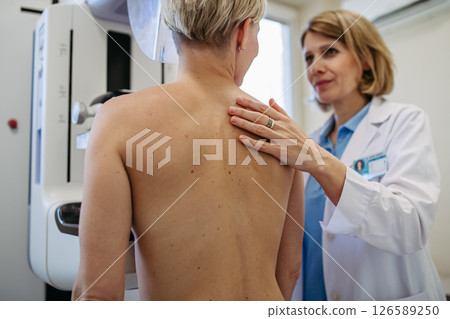 Radiologist comforting patient before mammogram screening. 126589250