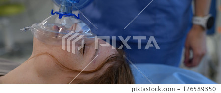 Medical staff applying oxygen mask to unconscious teenage girl in hospital. Medical staff applying oxygen mask to unconscious teenage girl in hospital. 126589350
