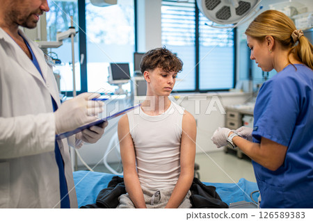 Vaccination of teenage boy during routine health checkup at hospital 126589383