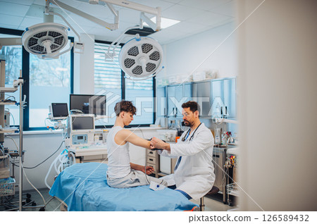 Teen boy undergoing medical checkup with doctor in hospital room. Teen boy undergoing medical checkup with doctor in hospital room. 126589432