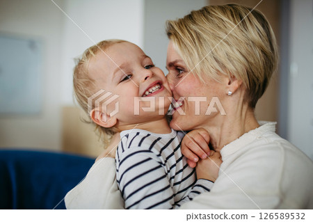 Beautiful mother hugging and kissing little son, 126589532