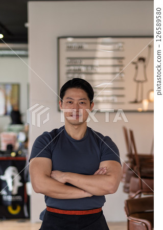 Athletic Asian man looking in camera, working as waiter. Athletic Asian man looking in camera, working as waiter. 126589580