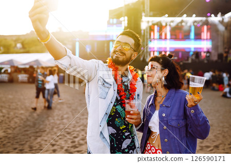 Young and cheerful couple at music festival. Happy friends drinking beer and having fun. 126590171