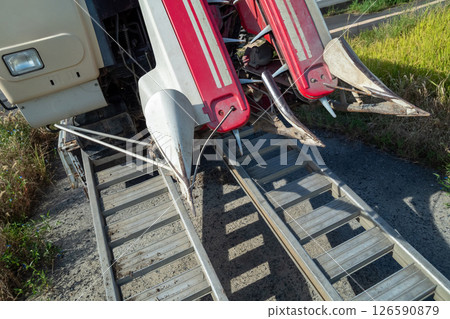 卡車上懸掛著一塊板，用於裝載和卸載聯合收割機。 126590879