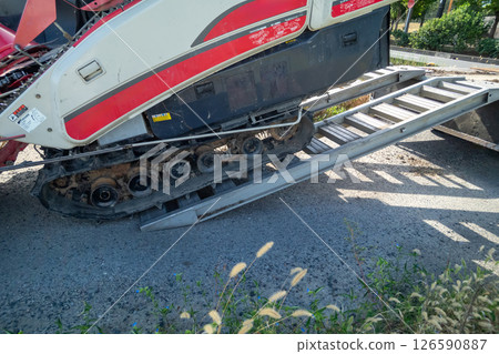 卡車上懸掛著一塊板，用於裝載和卸載聯合收割機。 126590887