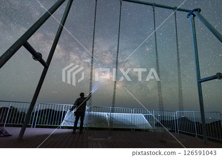 一個人看著星星的輪廓和鞦韆和美麗的銀河 126591043