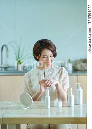 Woman applying cream to the back of her hand 126591053