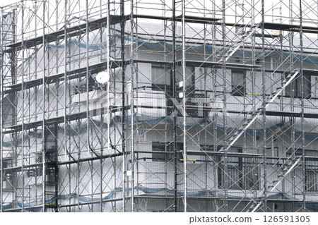 Yokohama cityscape in Japan. Apartment building repairs and inspections, scaffolding and protective nets. Satellite antennas outside the nets... Yokohama cityscape in Japan. Apartment building repairs and inspections, scaffolding and protective nets. Satellite antennas outside the nets... 126591305