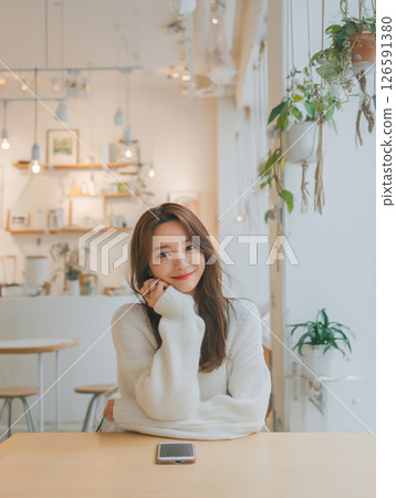 在咖啡館使用智慧型手機的年輕女子 126591380