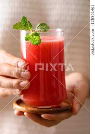 Fresh watermelon juice in glass holding by hand, Summer drink Fresh watermelon juice in glass holding by hand, Summer drink 126591462