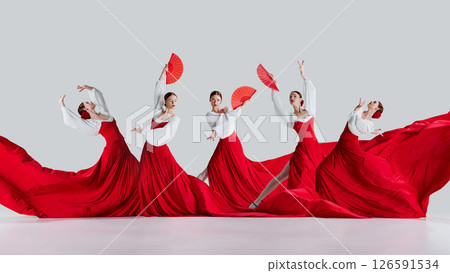 Dynamic collage. Flamenco dancer in red dresses striking elegant dramatic poses with fans and motion against white background 126591534
