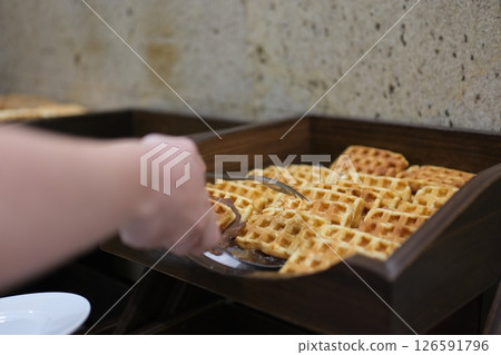 Golden crispy waffles Belgian waffles on a plate with rich liquid chocolate topping being poured over. Close-up, dolly shot capturing the delicious texture and sweet breakfast moment. Golden crispy waffles Belgian waffles on a plate with rich liquid chocolate topping being poured over. Close-up, dolly shot capturing the delicious texture and sweet breakfast moment. 126591796