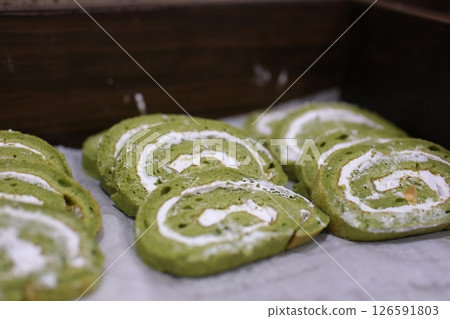 Green Swiss roll Green Tea Swiss Roll Cake with cream filling on cafe table. Matcha roll cake. breakfast at the buffet restaurant Green Swiss roll Green Tea Swiss Roll Cake with cream filling on cafe table. Matcha roll cake. breakfast at the buffet restaurant 126591803