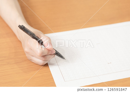 Image of a woman holding manuscript paper and pen (stock photo) 126591847