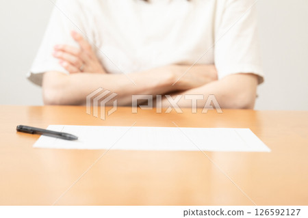 一名女子雙手交叉站在稿紙前（庫存照片） 126592127