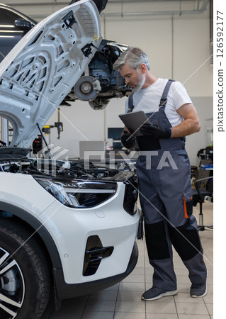 Mechanic using tablet for engine diagnostics 126592177