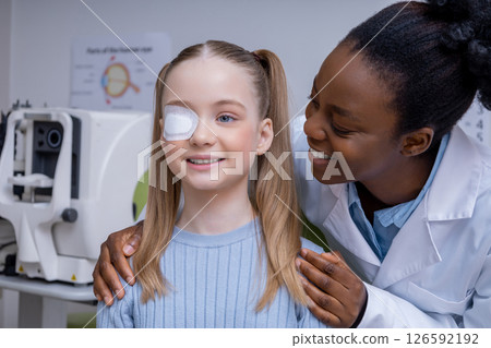 Girl having an exam at the ophthalmologist office and looking positive 126592192