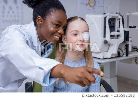 Girl having an exam at the ophthalmologist office and looking positive Girl having an exam at the ophthalmologist office and looking positive 126592198
