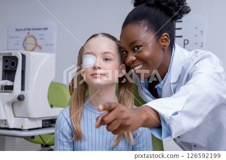 Caucasian school age girl undergoing vision exam at the ophthalmologist office Caucasian school age girl undergoing vision exam at the ophthalmologist office 126592199