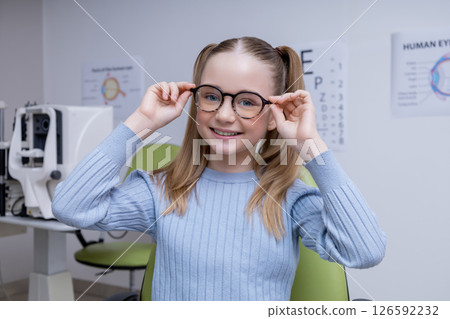 Cute caucasian girl in eyeglasses looking positive and contented 126592232