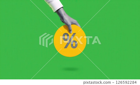 A hand reaches out to grasp a vibrant yellow circular symbol marked with a percentage sign set against a striking green backdrop. 126592284