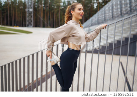Strong woman doing exercises outdoors in the morning. Active life, healthy lifestyle. Strong woman doing exercises outdoors in the morning. Active life, healthy lifestyle. 126592531