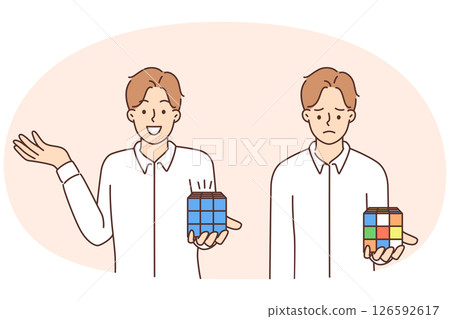 Sad and cheerful man holding Rubiks cube trying to assemble logic toy by solving puzzle 126592617