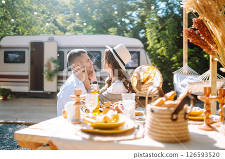 Beautiful wedding couple laugh and kiss relaxing in rv, camping in a trailer. Romantic moment. 126593520