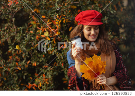 smiling woman in red hat with autumn leafs 126593833