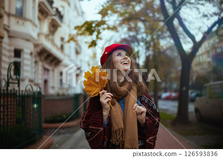 happy stylish woman in red hat with autumn leafs and scarf happy stylish woman in red hat with autumn leafs and scarf 126593836