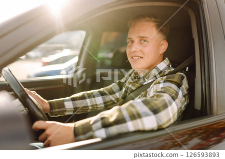 Happy man feeling comfortable sitting on driver seat in car. Lifestyle concept. Car sharing concept. Happy man feeling comfortable sitting on driver seat in car. Lifestyle concept. Car sharing concept. 126593893