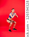 Athletic female performs exercises using a resistance band. Strength and motivation 126594328