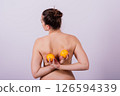 Naked woman back with an orange fruit the isolated image 126594339