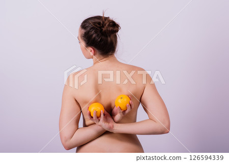 Naked woman back with an orange fruit the isolated image 126594339